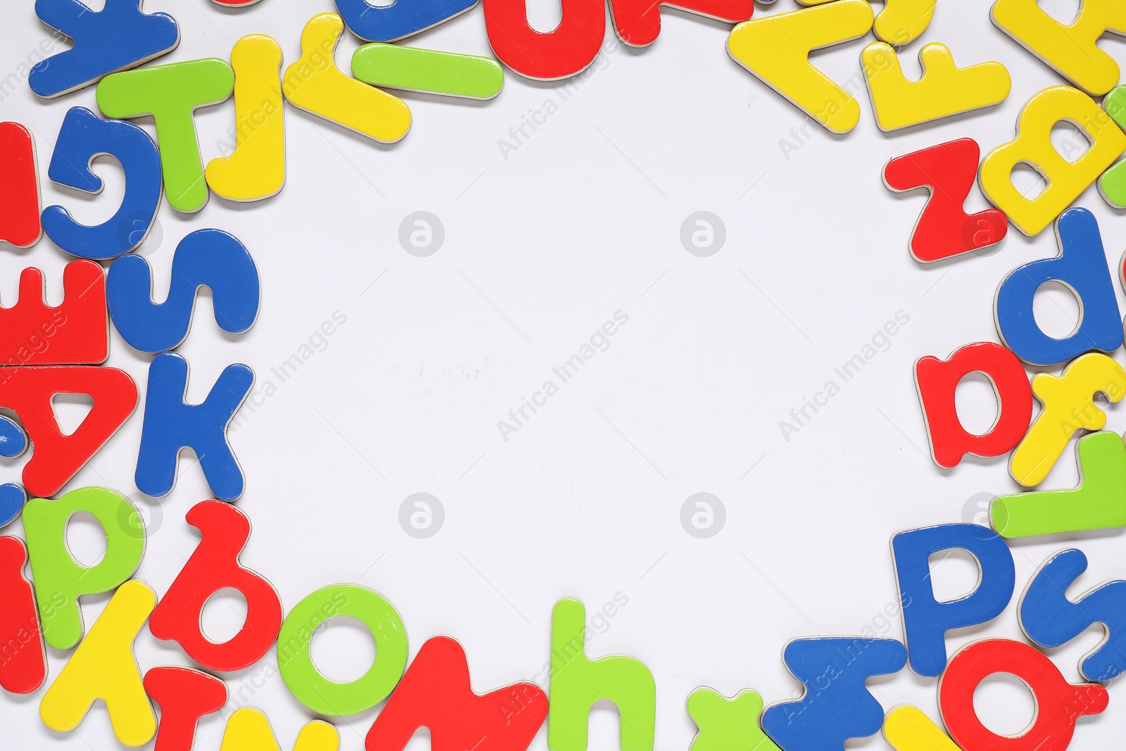 Photo of Alphabet. Many colorful magnetic letters isolated on white, top view