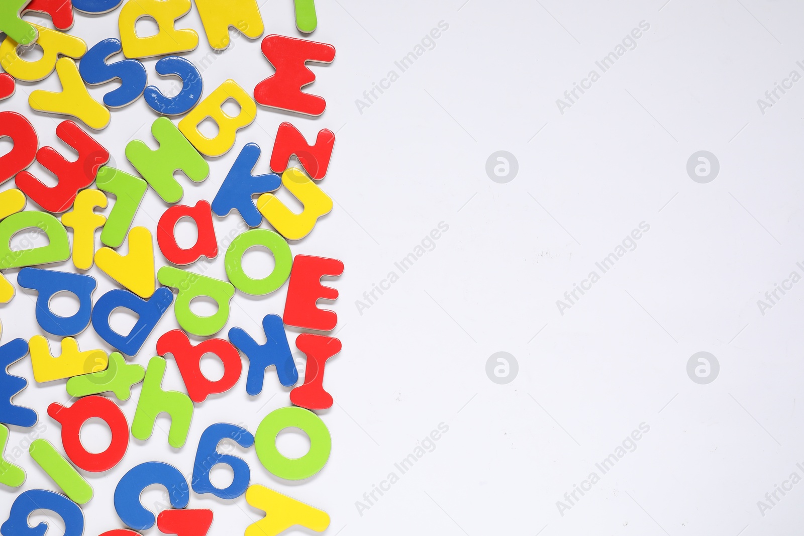 Photo of Alphabet. Many colorful magnetic letters isolated on white, top view