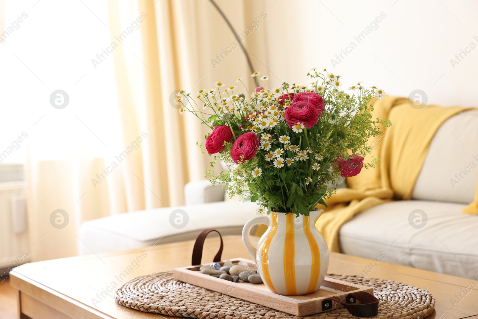 Photo of Beautiful ranunculus flowers and chamomiles in vase on table indoors, space for text