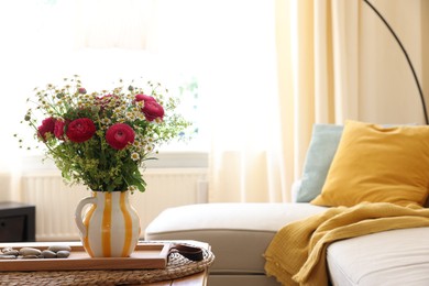 Beautiful ranunculus flowers and chamomiles in vase on table indoors, space for text