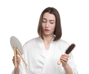 Young woman with hair loss problem looking at mirror on white background