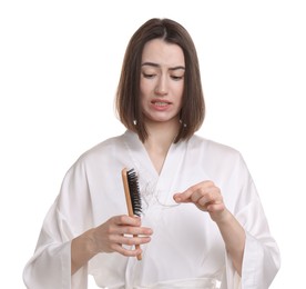 Emotional woman taking her lost hair from brush on white background. Alopecia problem