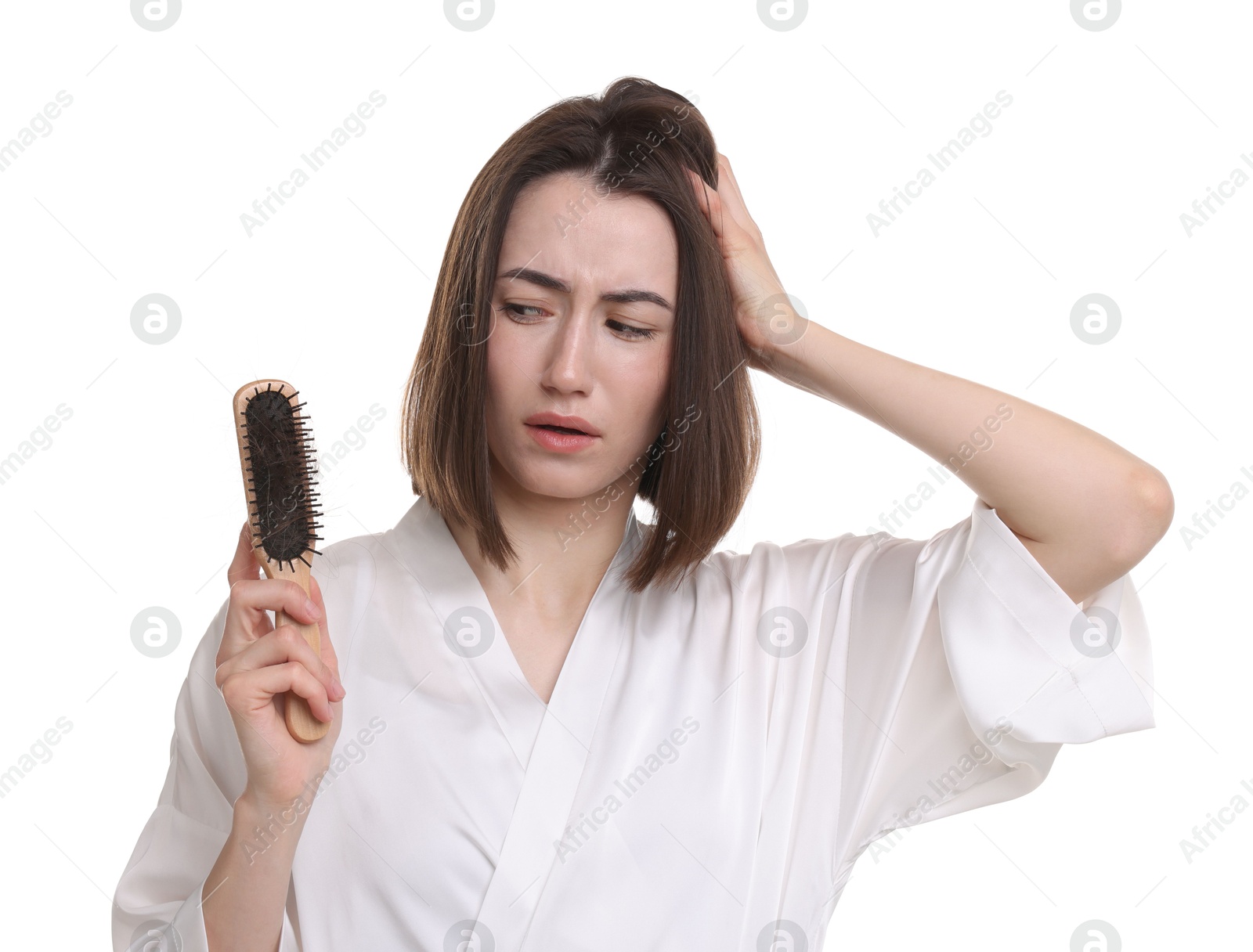 Photo of Stressed woman holding brush with lost hair on white background. Alopecia problem