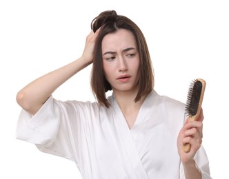 Stressed woman holding brush with lost hair on white background. Alopecia problem