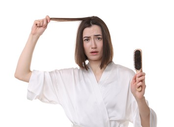 Photo of Stressed woman holding brush with lost hair on white background. Alopecia problem