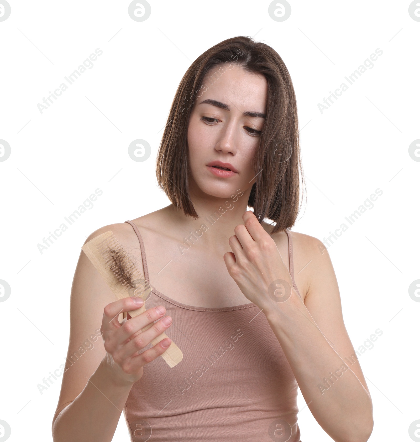 Photo of Stressed woman holding comb with lost hair on white background. Alopecia problem