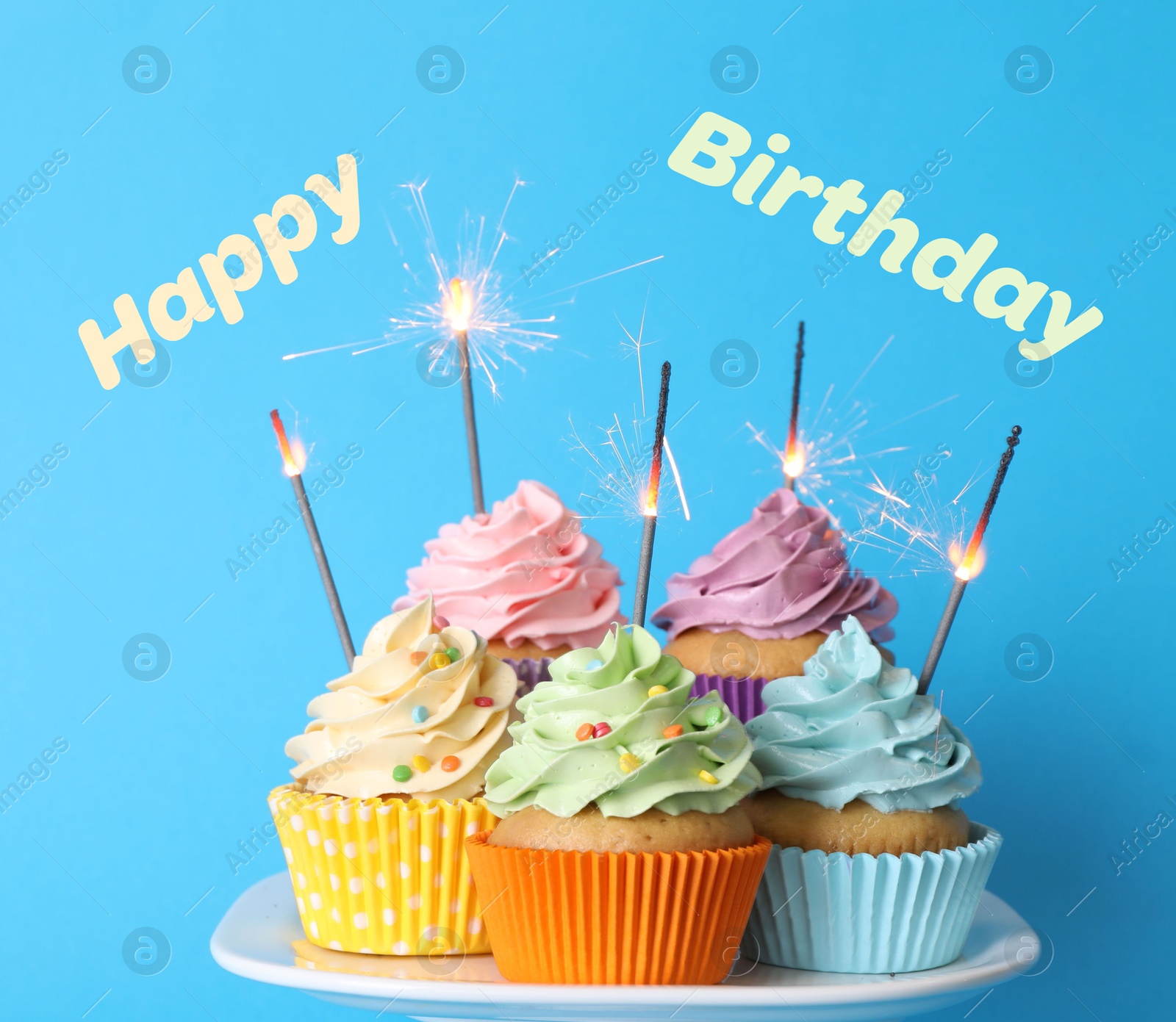 Image of Happy Birthday. Cupcakes with sparklers on light blue background