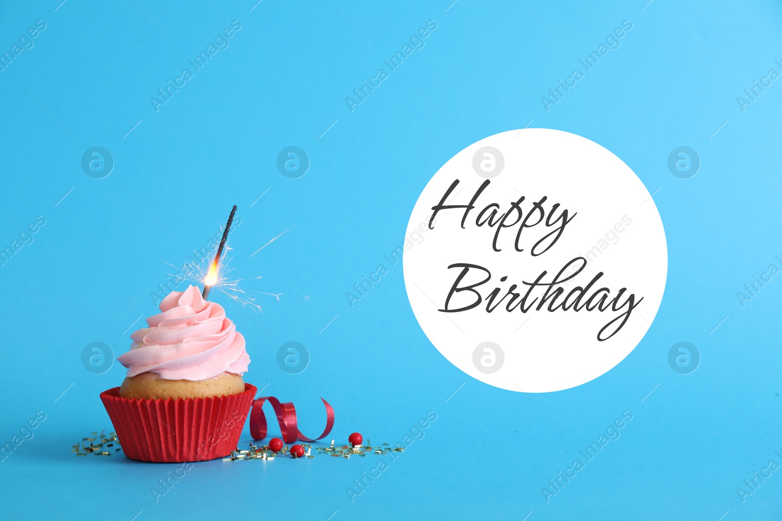 Image of Birthday cupcake with sparkler on light blue background. Greeting card