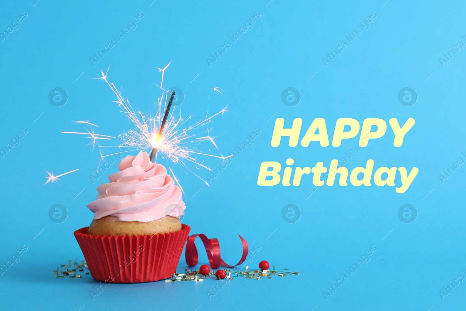 Image of Birthday cupcake with sparkler on light blue background. Greeting card