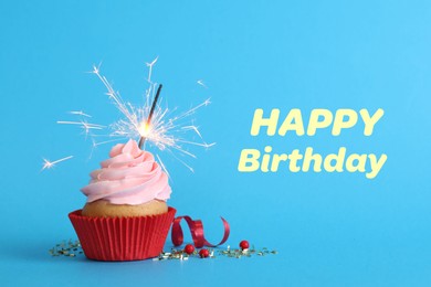 Image of Birthday cupcake with sparkler on light blue background. Greeting card