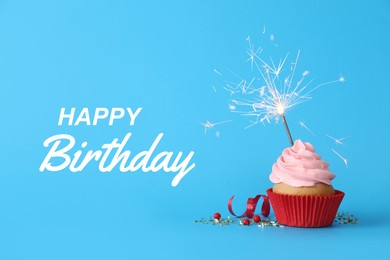 Image of Birthday cupcake with sparkler on light blue background. Greeting card