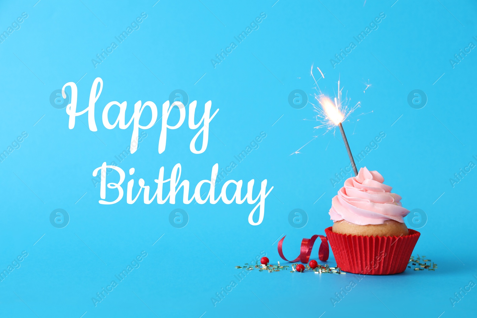 Image of Birthday cupcake with sparkler on light blue background. Greeting card