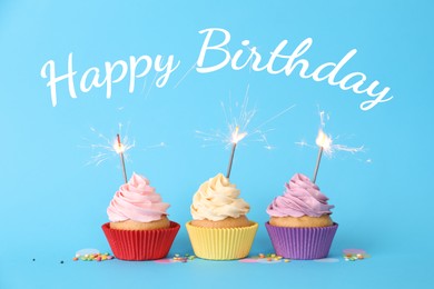 Image of Happy Birthday. Cupcakes with sparklers on light blue background