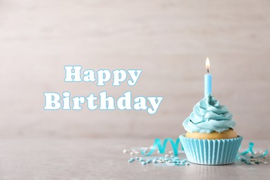 Image of Happy Birthday. Cupcake with candle on table against light background