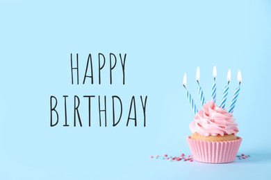 Image of Birthday cupcake with candles on light blue background. Greeting card