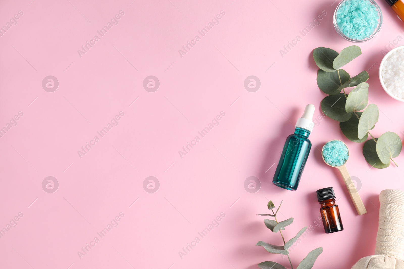 Photo of Different aromatherapy products and eucalyptus branches on pink background, flat lay. Space for text