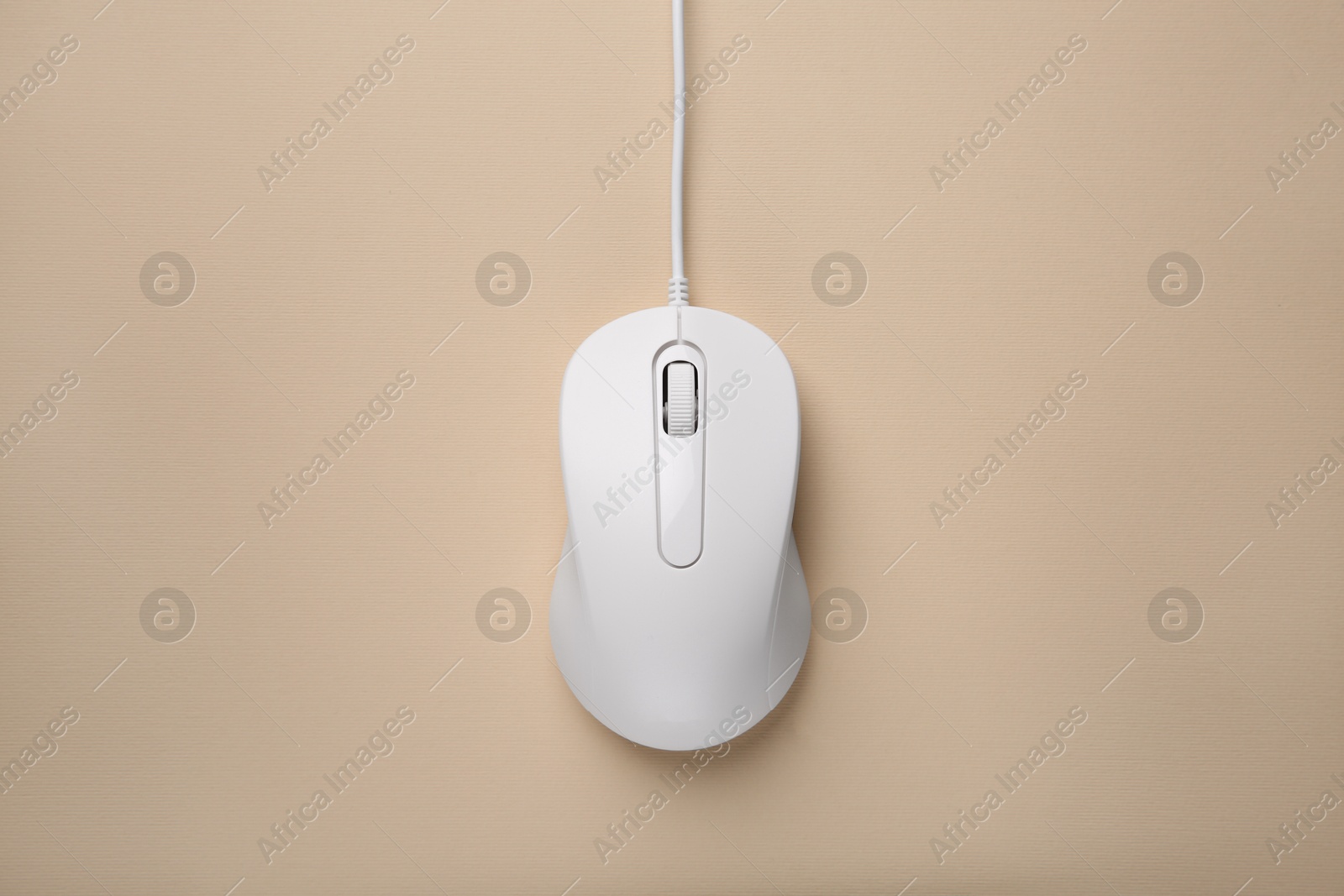 Photo of One wired mouse on beige background, top view