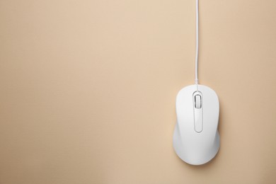 Photo of One wired mouse on beige background, top view. Space for text