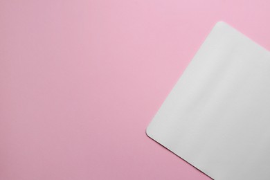 One mouse pad on pink background, top view. Space for text