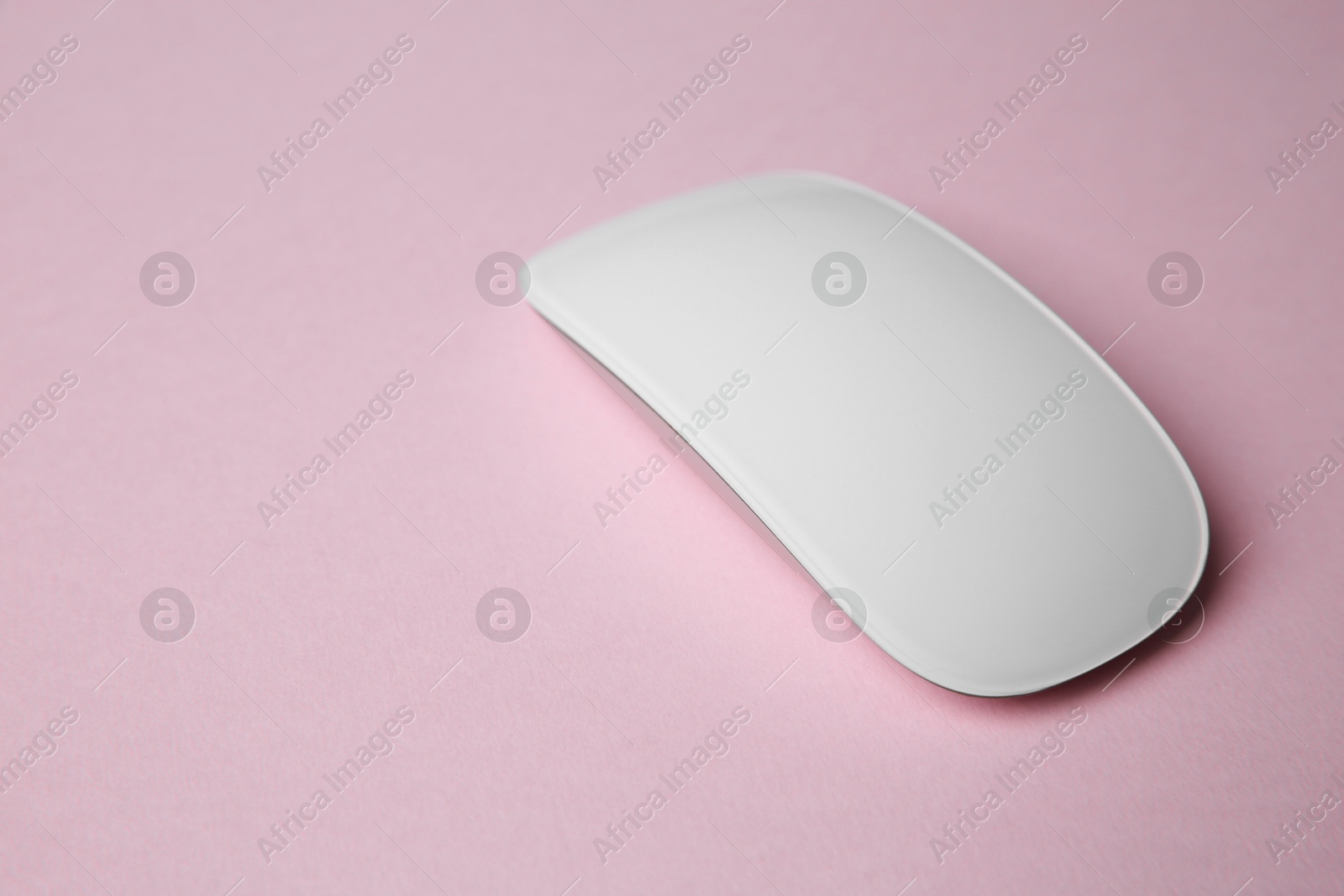 Photo of One wireless mouse on pink background. Space for text