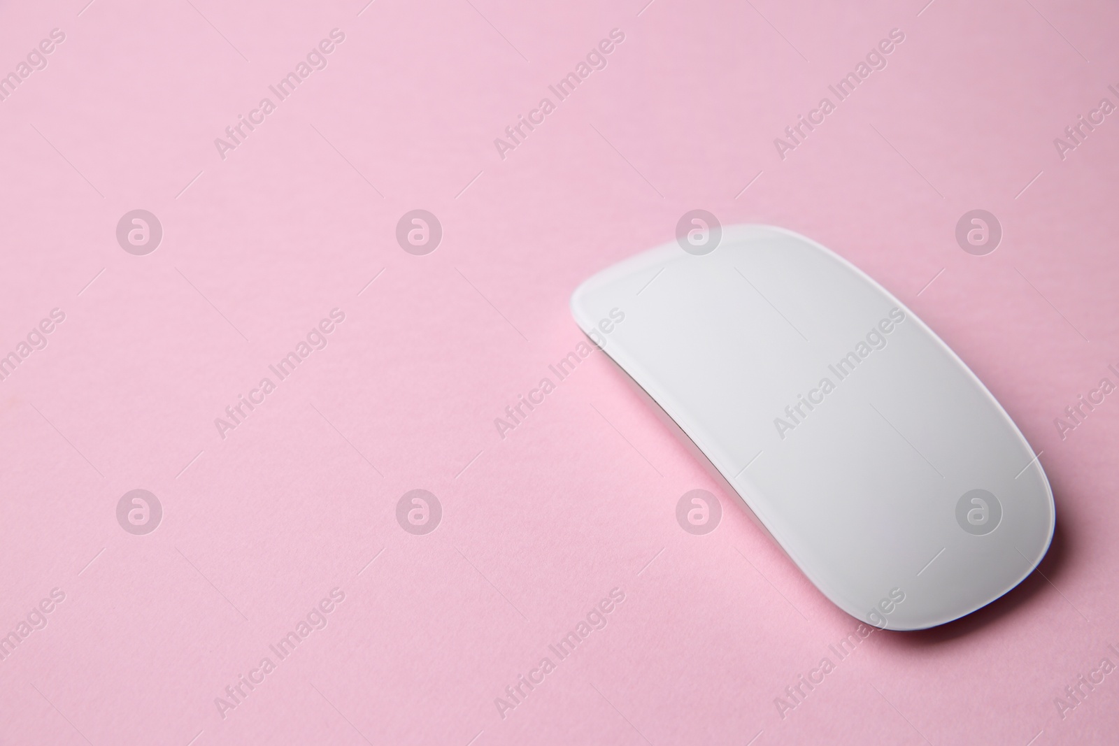 Photo of One wireless mouse on pink background. Space for text