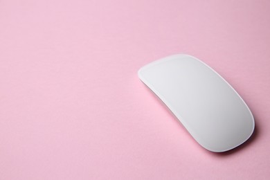 One wireless mouse on pink background. Space for text