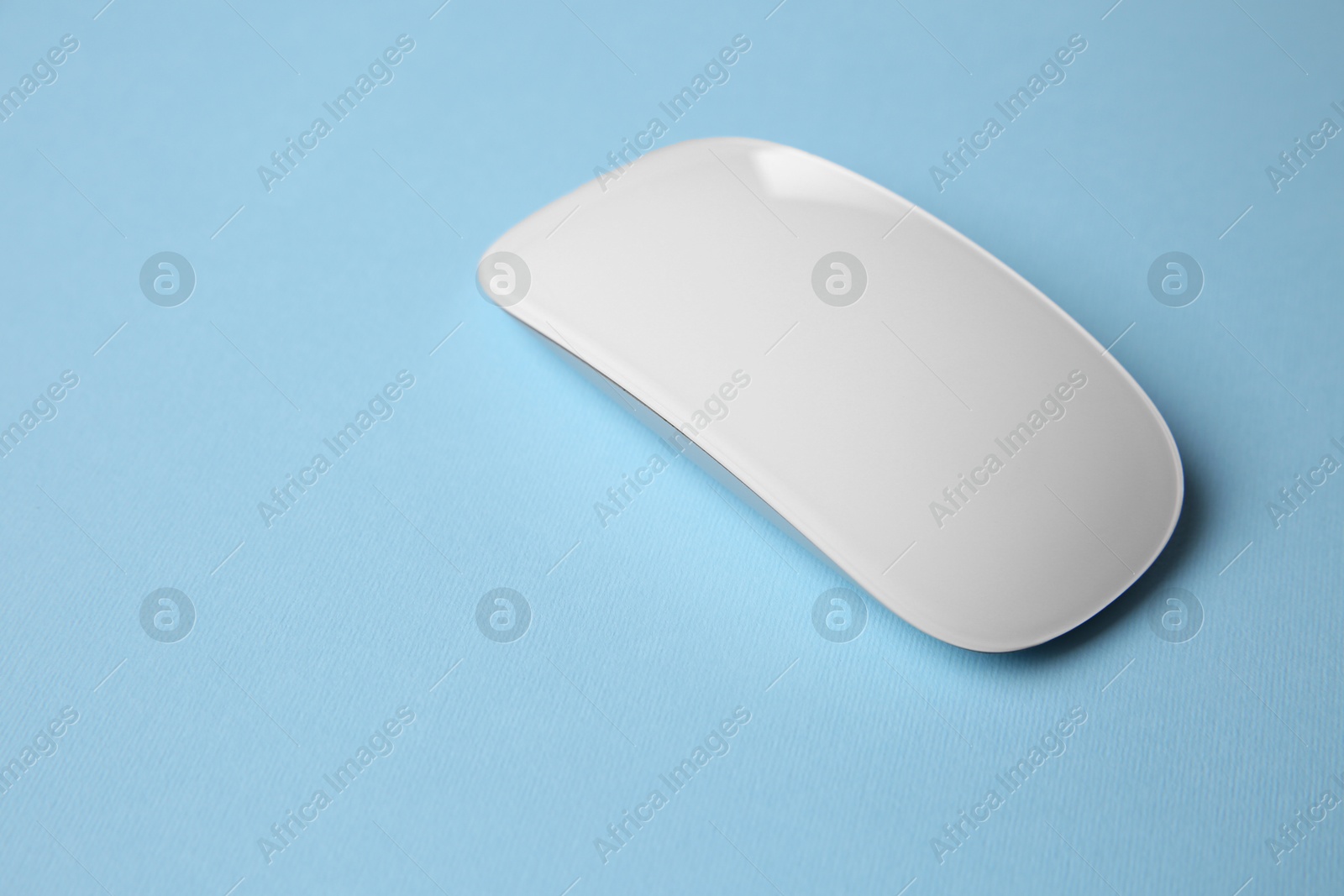 Photo of One wireless mouse on light blue background. Space for text