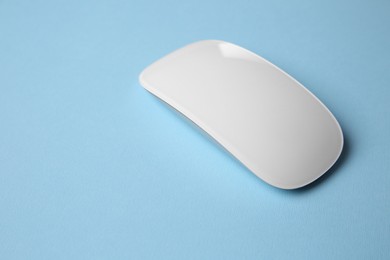 One wireless mouse on light blue background. Space for text