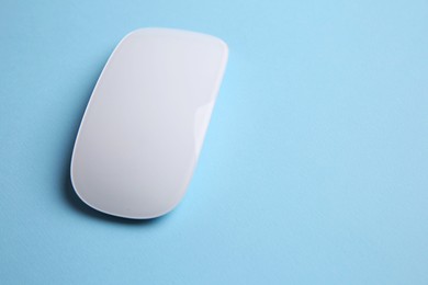 Photo of One wireless mouse on light blue background. Space for text