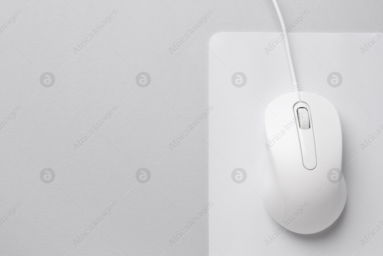 Photo of Wired mouse with mousepad on grey background, top view. Space for text