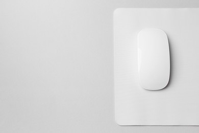 One wireless mouse with mousepad on grey background, top view. Space for text