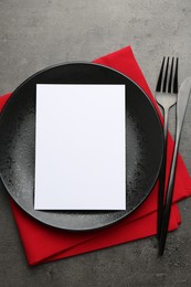 Photo of Empty menu, plate, cutlery and napkin on grey table, top view. Mockup for design