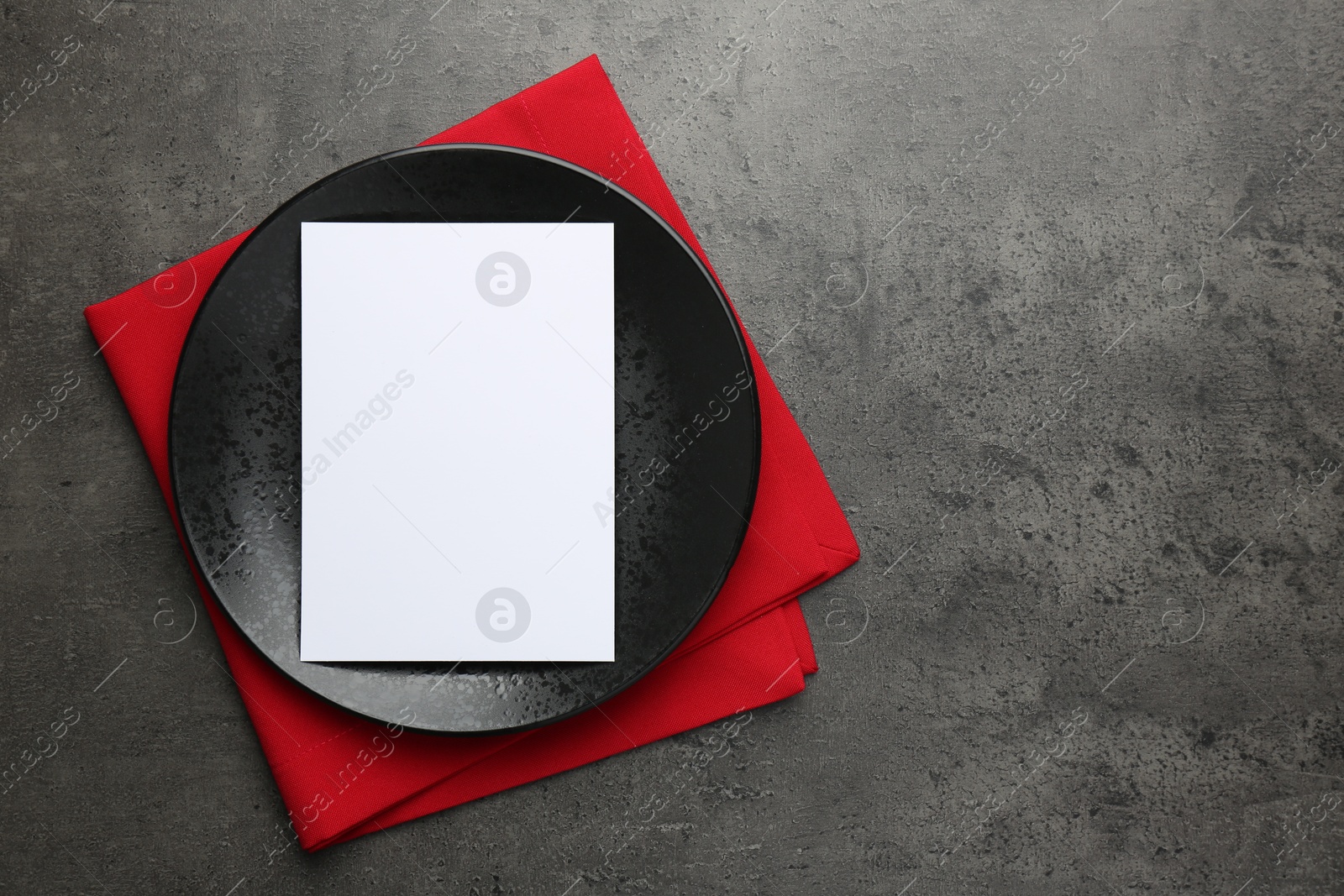 Photo of Empty menu, plate and napkin on grey table, top view. Mockup for design