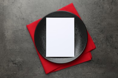 Photo of Empty menu, plate and napkin on grey table, top view. Mockup for design