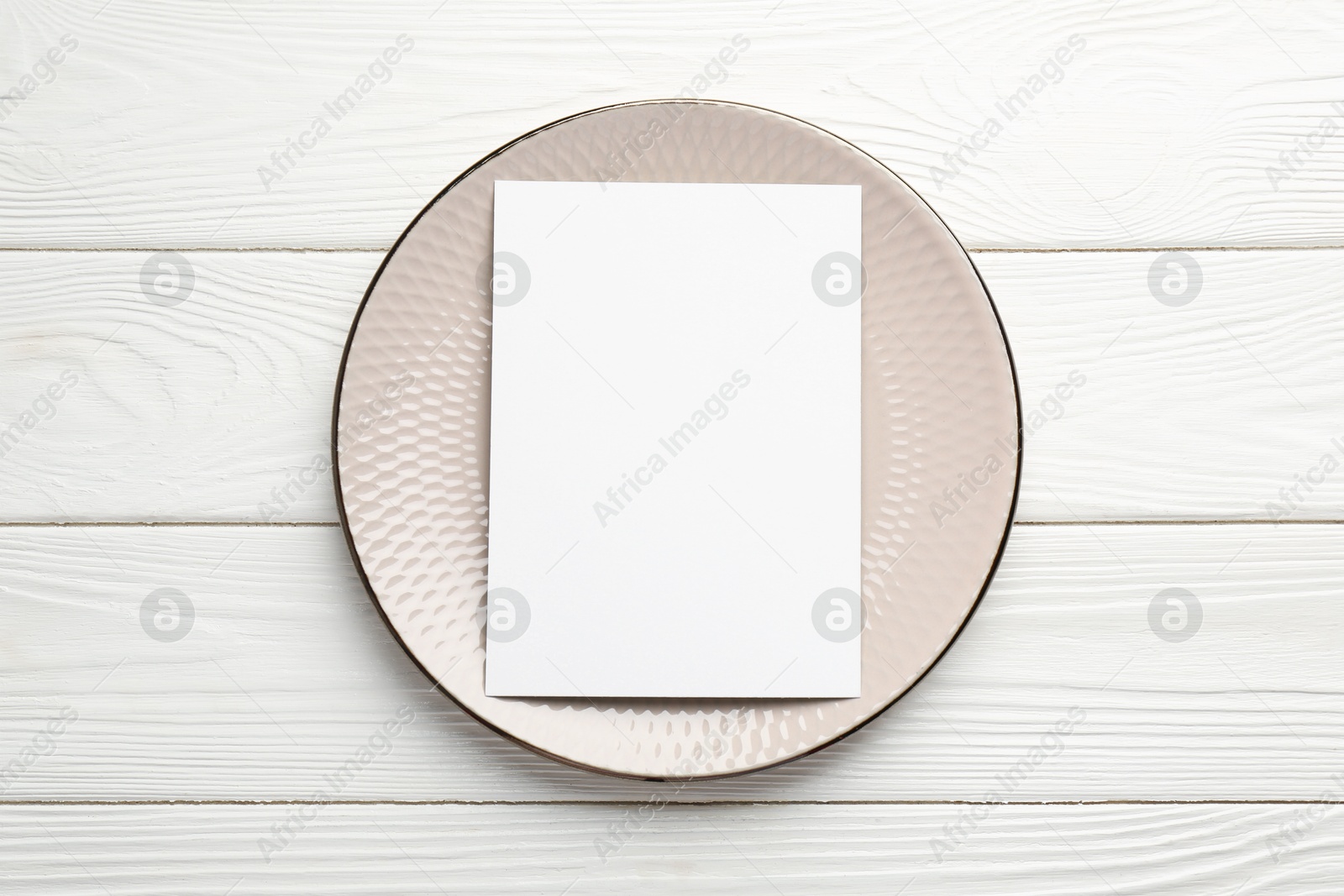 Photo of Empty menu and plate on white wooden table, top view. Mockup for design