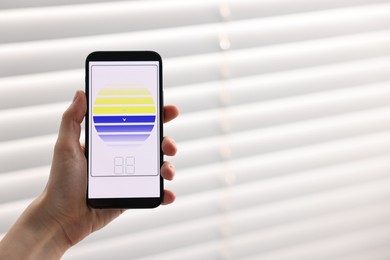 Photo of Woman using smartphone to adjust window blinds indoors, closeup. Space for text