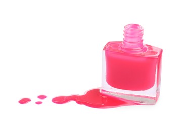 Bottle and spilled pink nail polish isolated on white