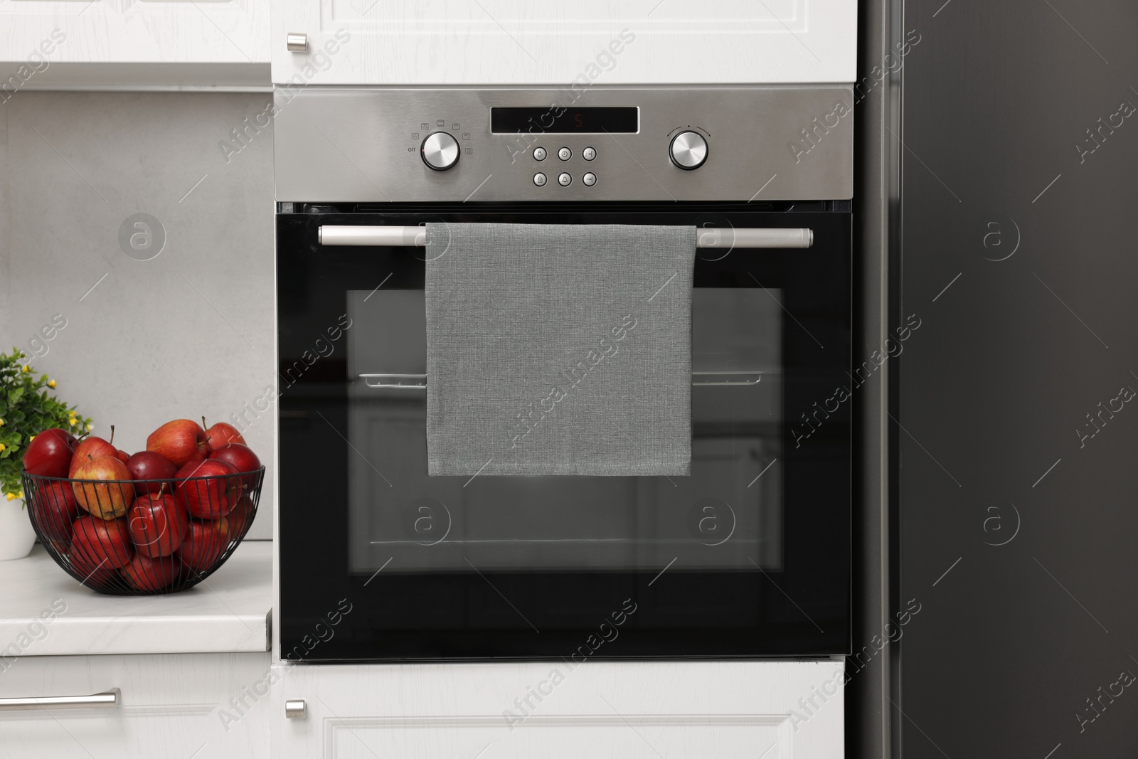 Photo of Electric oven with towel in kitchen. Cooking appliance