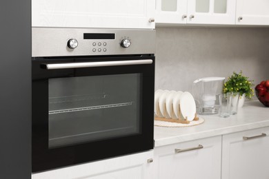 Photo of New electric oven in kitchen. Cooking appliance