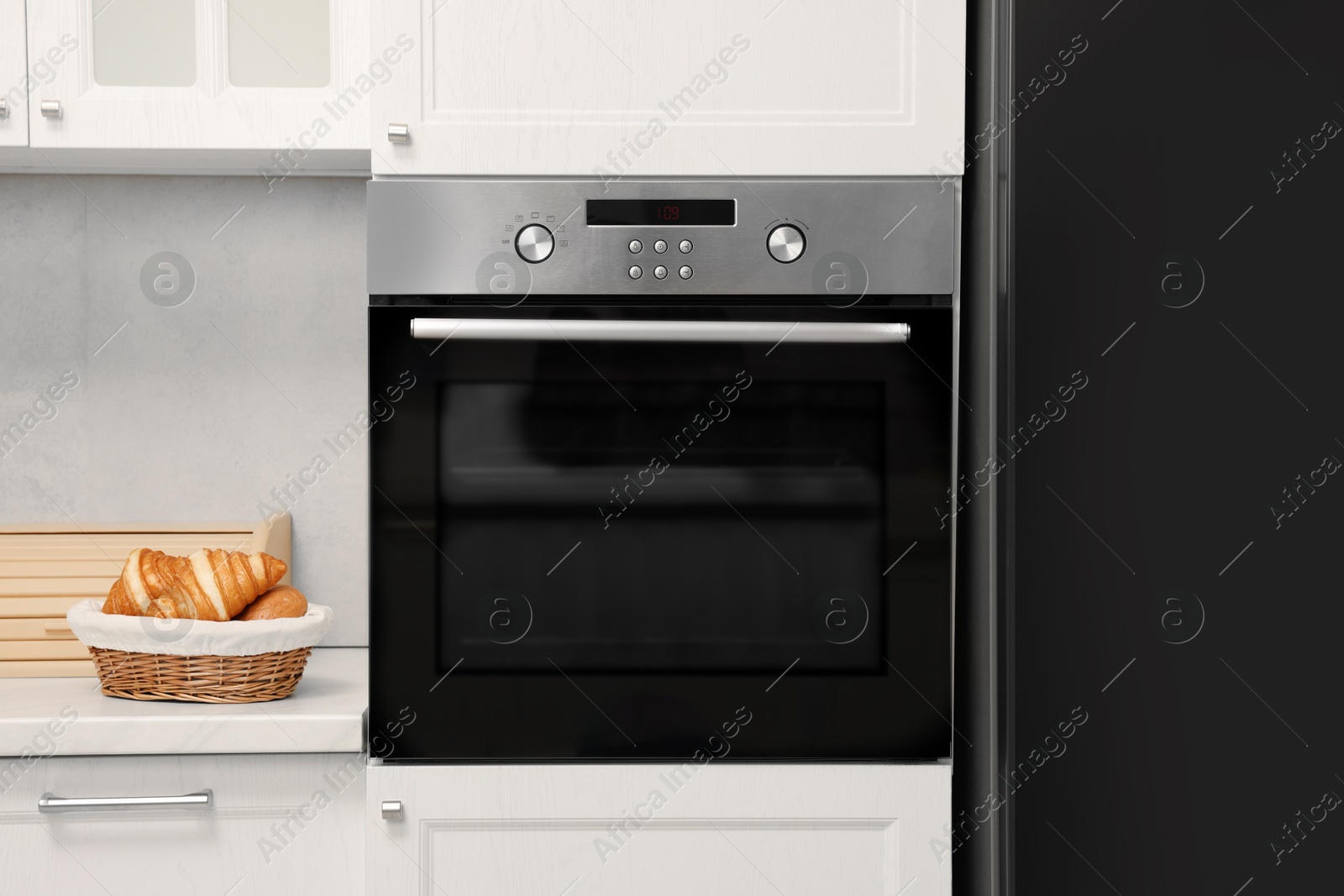 Photo of Electric oven and croissants in kitchen. Cooking appliance