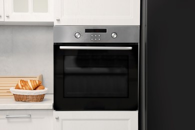 Electric oven and croissants in kitchen. Cooking appliance