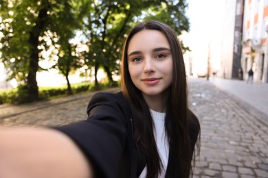 Beautiful young travel blogger takIng selfie outdoors