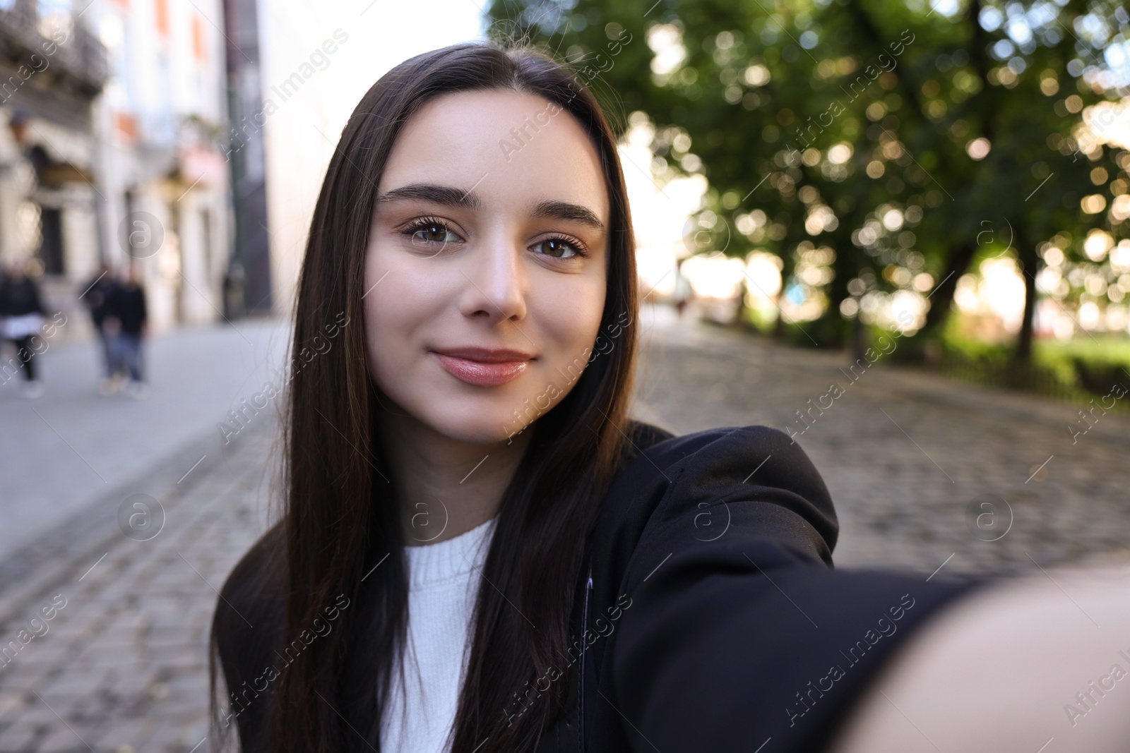 Photo of Beautiful young travel blogger takIng selfie outdoors