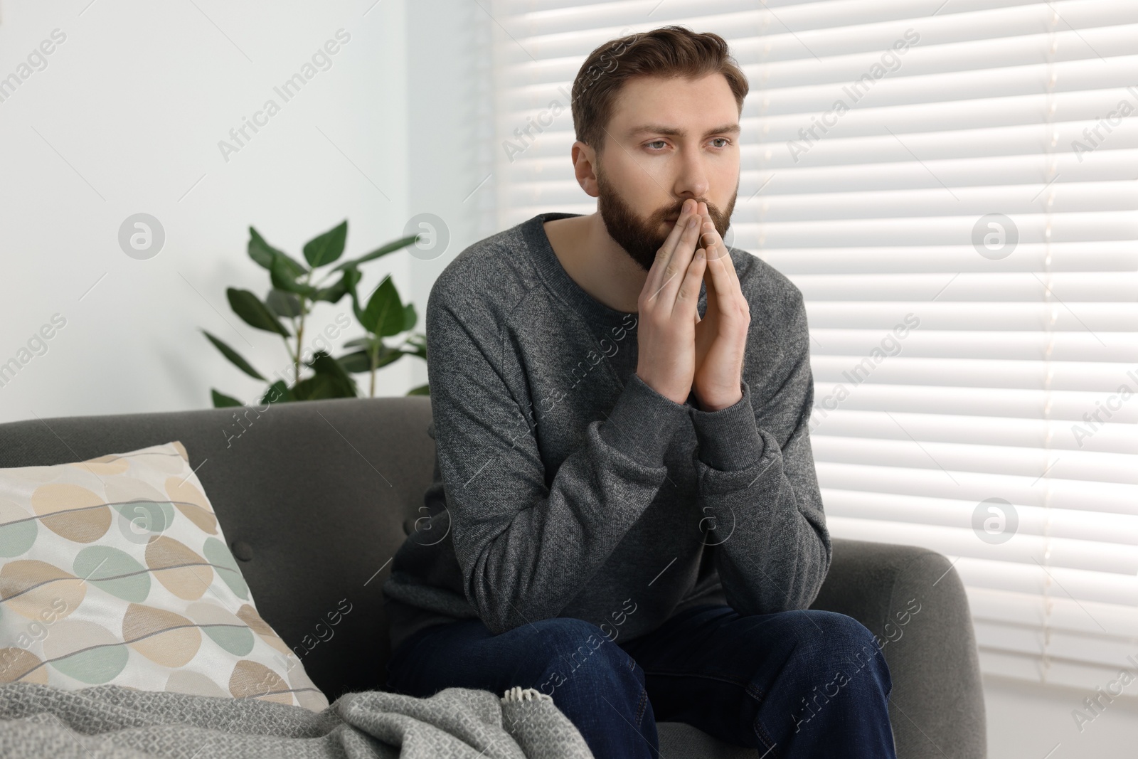 Photo of Loneliness concept. Sad man sitting on sofa at home