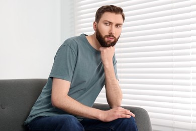 Photo of Loneliness concept. Sad man sitting on sofa at home