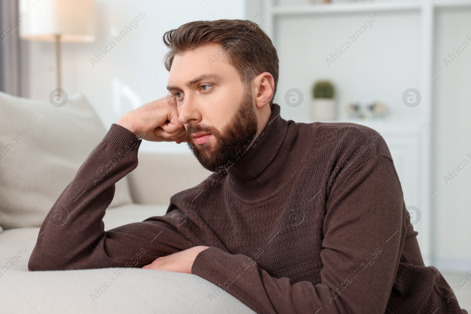 Photo of Loneliness concept. Sad man sitting on sofa at home