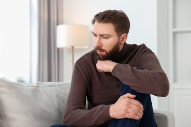 Photo of Loneliness concept. Sad man sitting on sofa at home