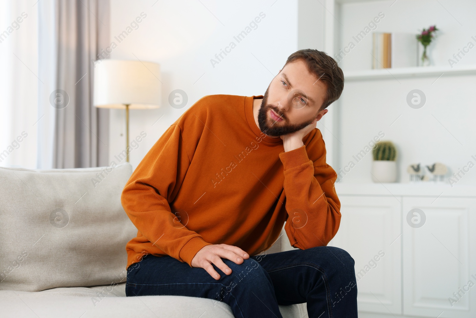 Photo of Loneliness concept. Sad man sitting on sofa at home