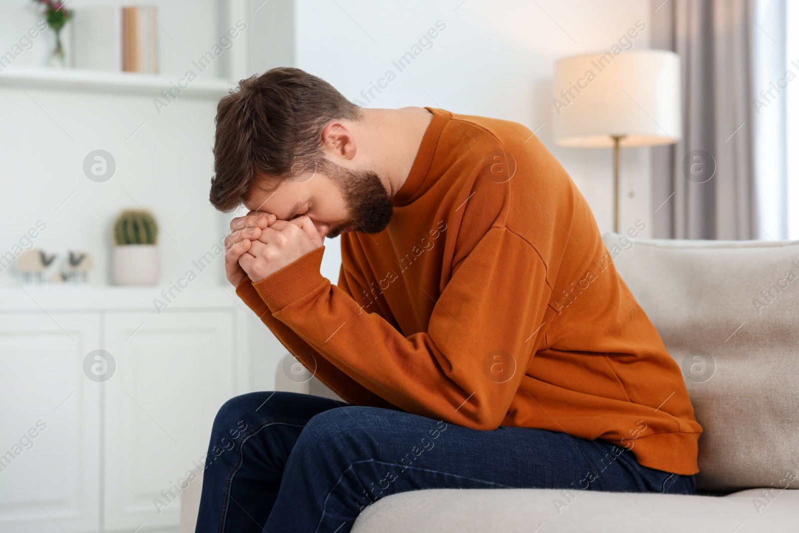 Photo of Loneliness concept. Sad man sitting on sofa at home