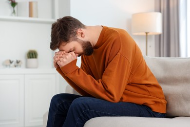 Photo of Loneliness concept. Sad man sitting on sofa at home